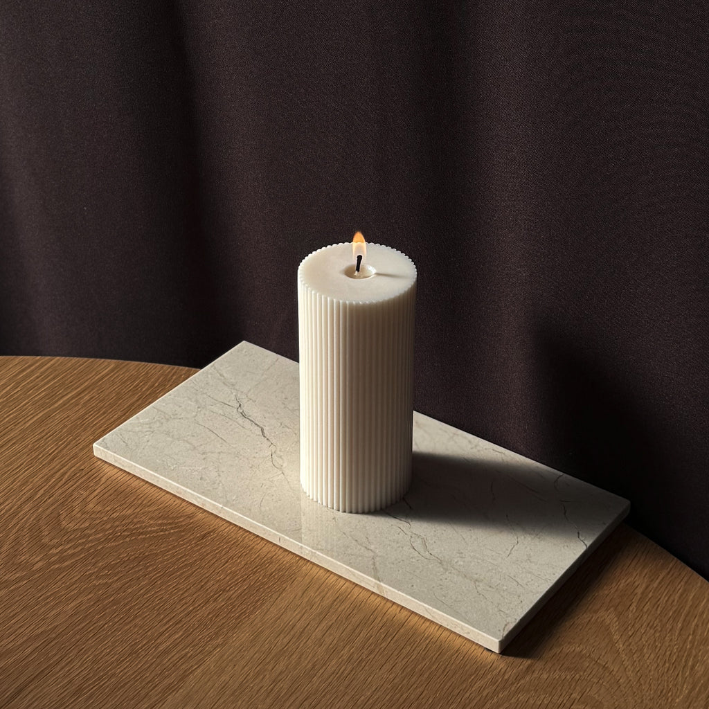 ROMI Kerze, minimalistisches Design, moderne Beleuchtung, skandinavischer Stil, gerippte Kerze, elegantes Wohnaccessoire, dezent stilvoll, Atmosphäre schaffen, sanfte Beleuchtung, zurückhaltende Eleganz.
