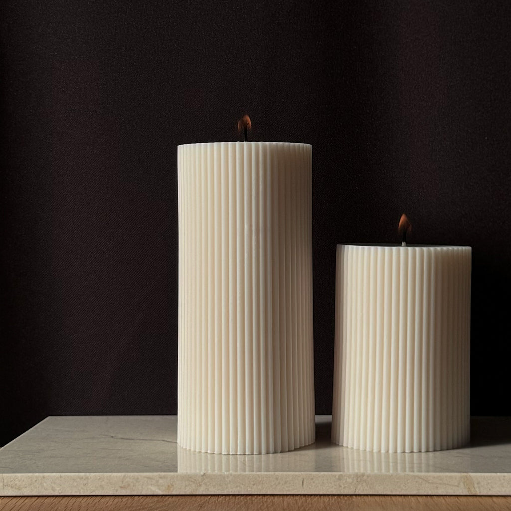 RUNA Kerze, minimalistisches Design, moderne Beleuchtung, skandinavischer Stil, gerippte Kerze, elegantes Wohnaccessoire, dezent stilvoll, Atmosphäre schaffen, sanfte Beleuchtung, zurückhaltende Eleganz.
