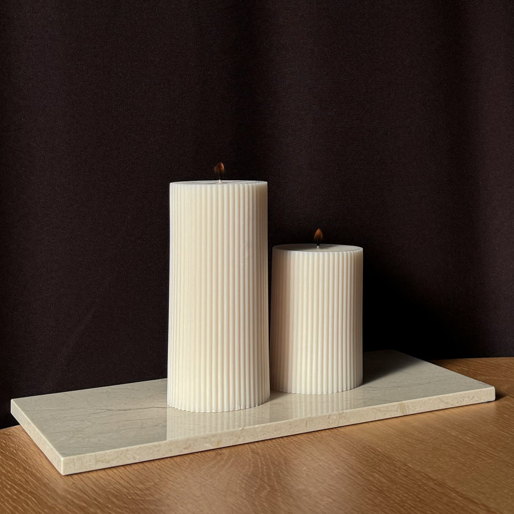 ROMI Kerze, minimalistisches Design, moderne Beleuchtung, skandinavischer Stil, gerippte Kerze, elegantes Wohnaccessoire, dezent stilvoll, Atmosphäre schaffen, sanfte Beleuchtung, zurückhaltende Eleganz.
