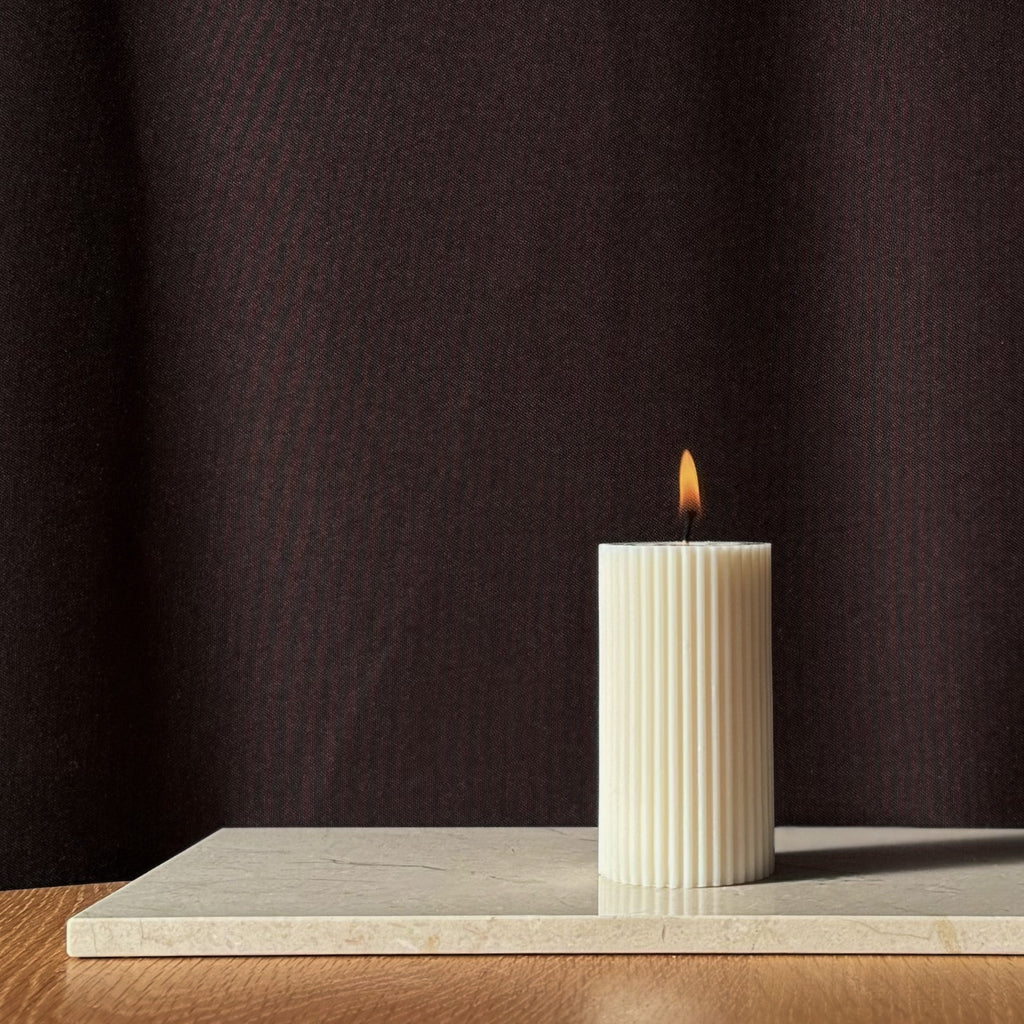 RUNA Kerze, minimalistisches Design, moderne Beleuchtung, skandinavischer Stil, gerippte Kerze, elegantes Wohnaccessoire, dezent stilvoll, Atmosphäre schaffen, sanfte Beleuchtung, zurückhaltende Eleganz.
