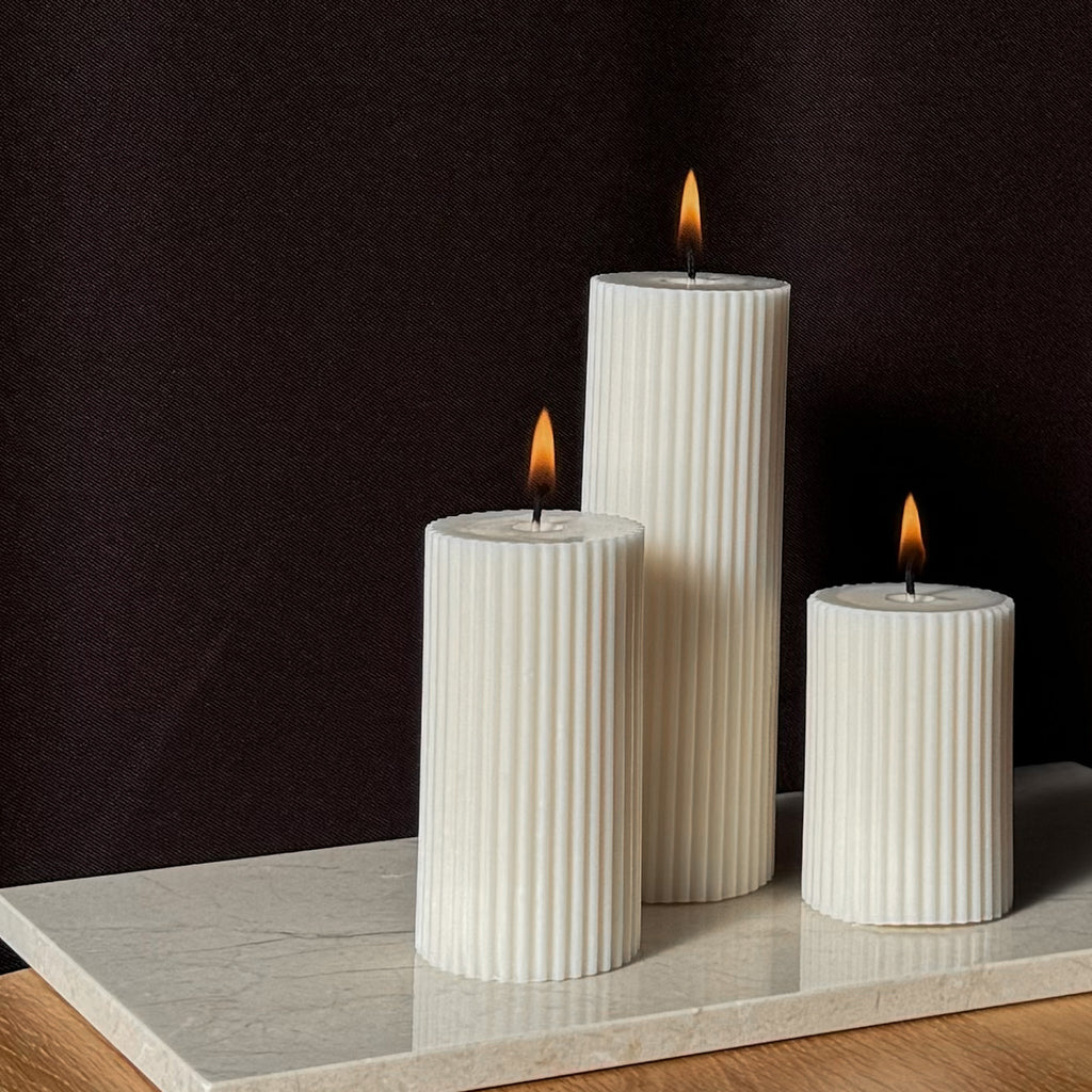 RUNA Kerze, minimalistisches Design, moderne Beleuchtung, skandinavischer Stil, gerippte Kerze, elegantes Wohnaccessoire, dezent stilvoll, Atmosphäre schaffen, sanfte Beleuchtung, zurückhaltende Eleganz.
