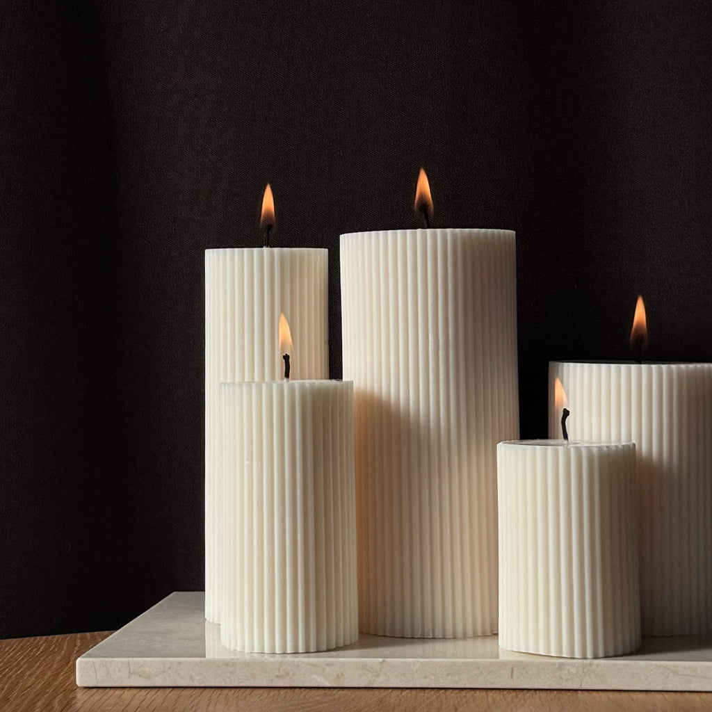 RUNA Kerze, minimalistisches Design, moderne Beleuchtung, skandinavischer Stil, gerippte Kerze, elegantes Wohnaccessoire, dezent stilvoll, Atmosphäre schaffen, sanfte Beleuchtung, zurückhaltende Eleganz.
