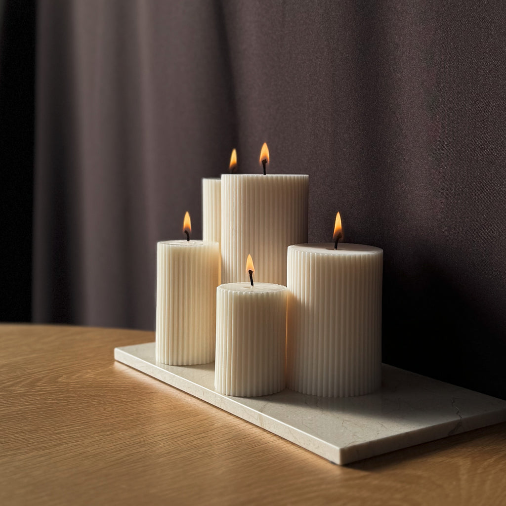 RUNA Kerze, minimalistisches Design, moderne Beleuchtung, skandinavischer Stil, gerippte Kerze, elegantes Wohnaccessoire, dezent stilvoll, Atmosphäre schaffen, sanfte Beleuchtung, zurückhaltende Eleganz.
