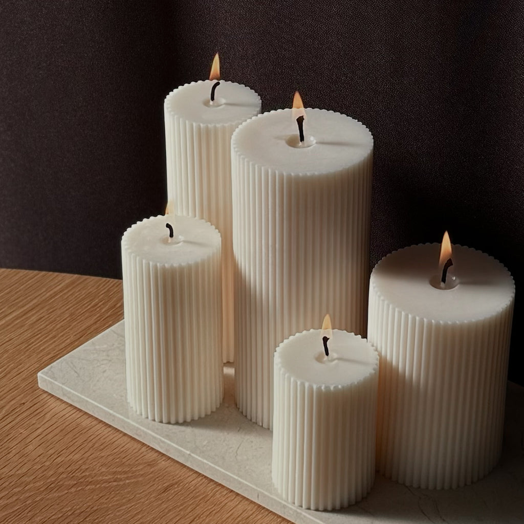 RUNA Kerze, minimalistisches Design, moderne Beleuchtung, skandinavischer Stil, gerippte Kerze, elegantes Wohnaccessoire, dezent stilvoll, Atmosphäre schaffen, sanfte Beleuchtung, zurückhaltende Eleganz.
