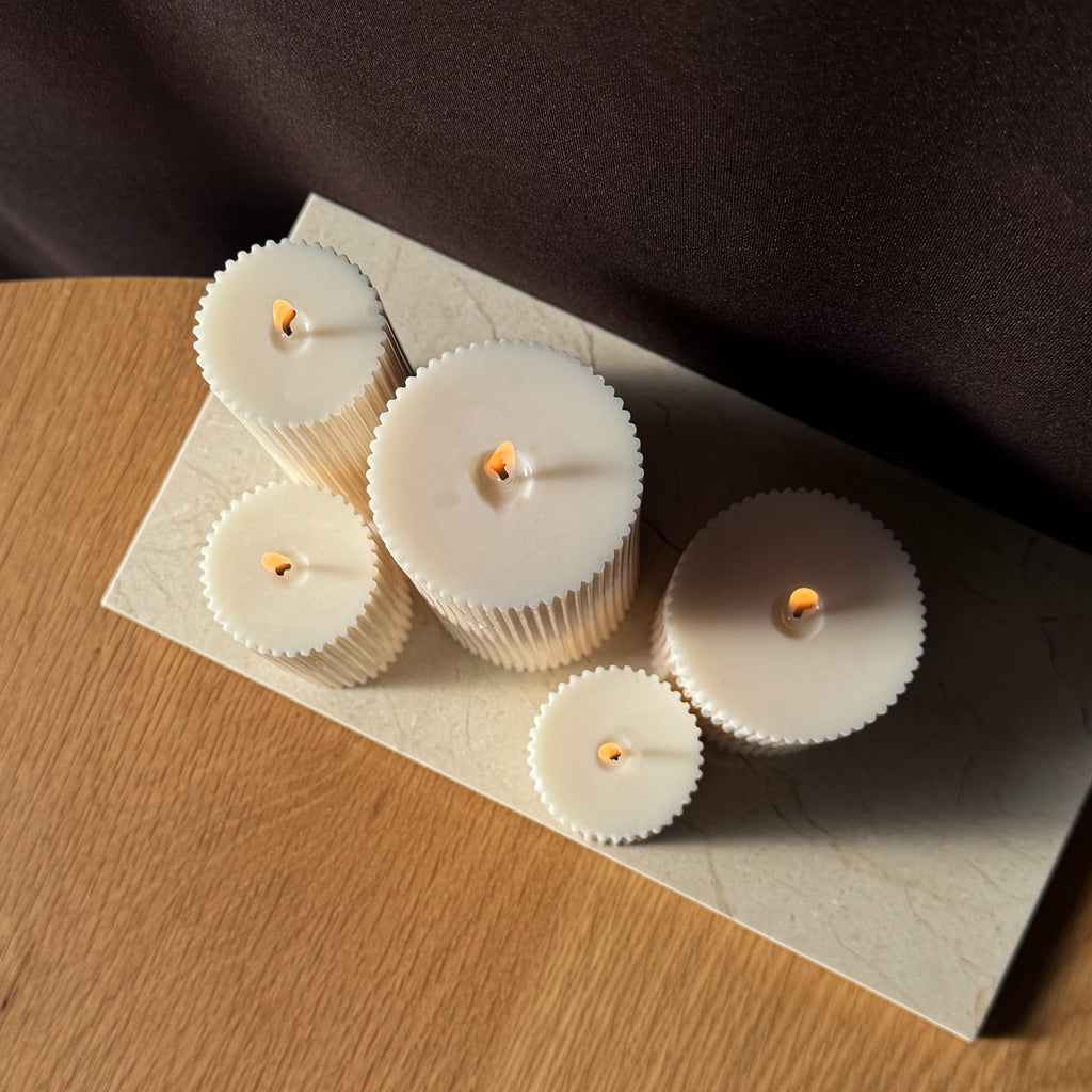 RUNA Kerze, minimalistisches Design, moderne Beleuchtung, skandinavischer Stil, gerippte Kerze, elegantes Wohnaccessoire, dezent stilvoll, Atmosphäre schaffen, sanfte Beleuchtung, zurückhaltende Eleganz.
