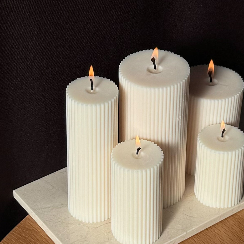 RUNA Kerze, minimalistisches Design, moderne Beleuchtung, skandinavischer Stil, gerippte Kerze, elegantes Wohnaccessoire, dezent stilvoll, Atmosphäre schaffen, sanfte Beleuchtung, zurückhaltende Eleganz.
